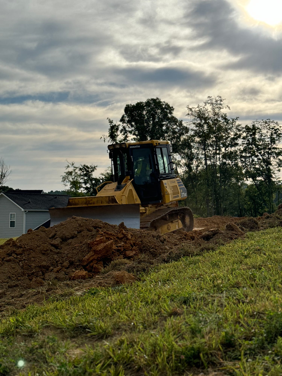 Dozer pushing cut material on a residential lot at the end of the day