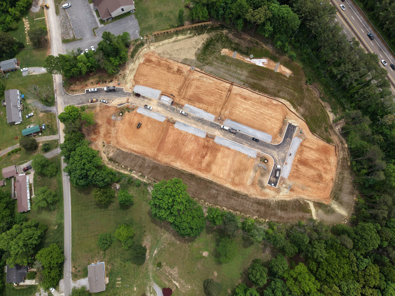 Aerial view of graded lots with a new street and drive aprons in place