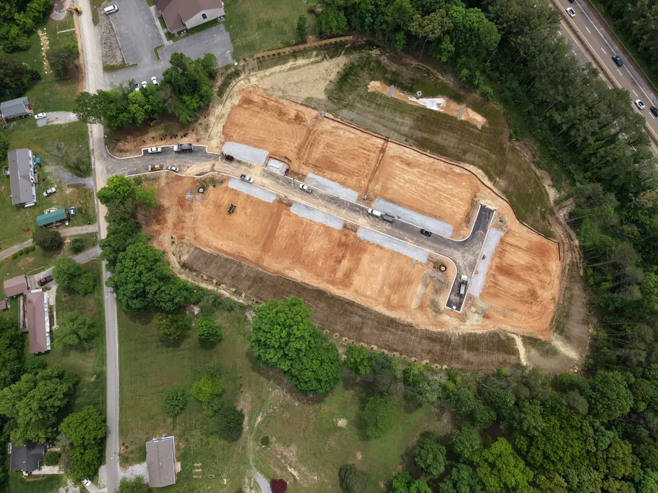 Aerial view of graded lots with a new street and drive aprons in place