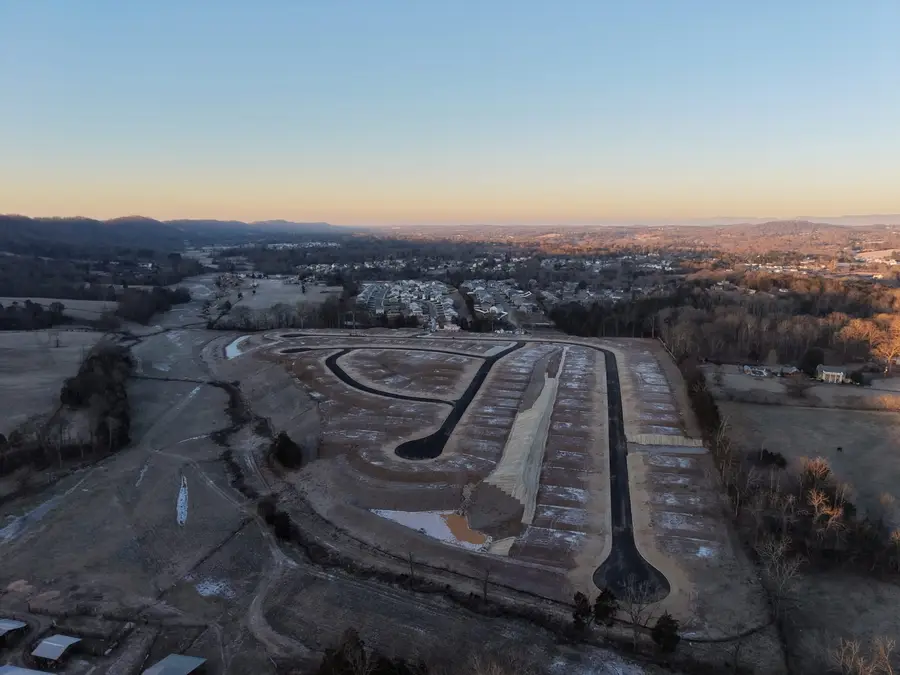 Aerial view of Belhaven subdivision at dusk with paved streets and graded lots